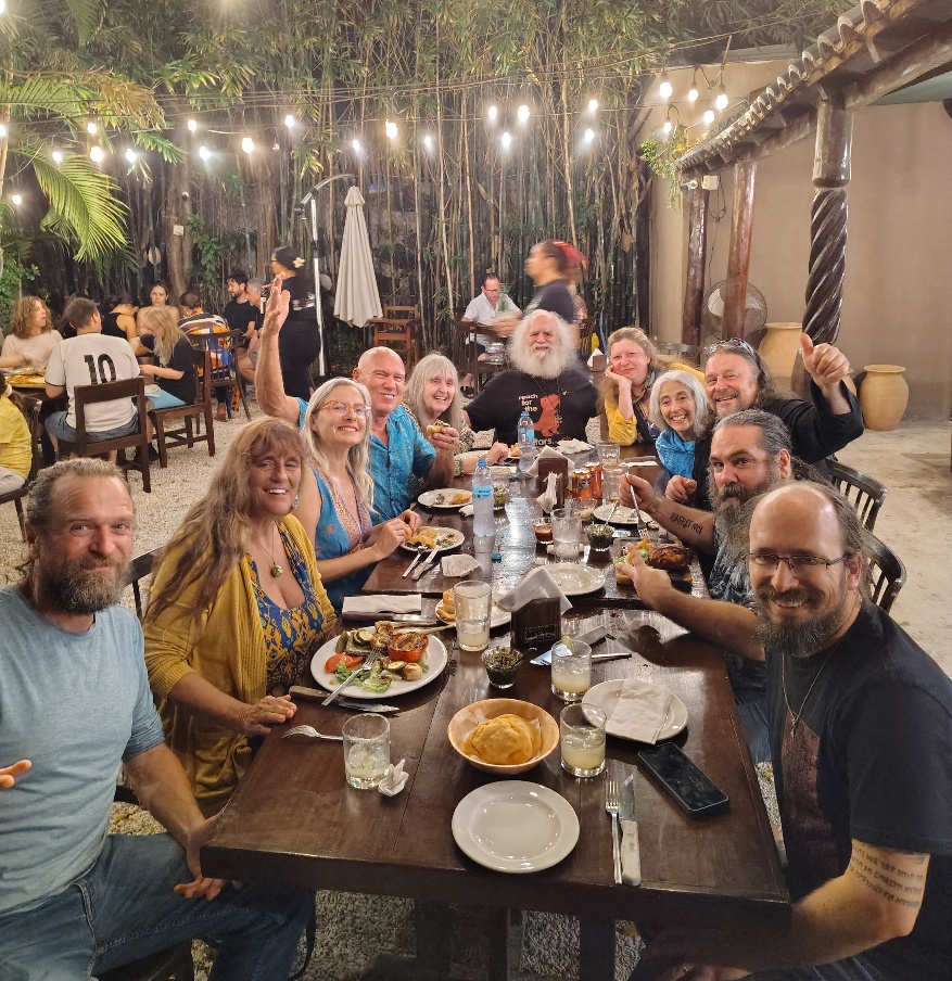 A Picture of Dinner David, Jiva, April, Russell, Dona, OZ, Patricia, Beth, Diego, Sundance, Ryan all seated around an outdoor table, having dinner.