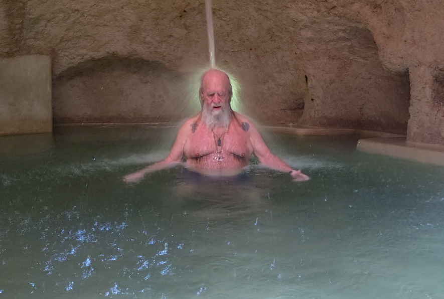 Photo of OZ sitting under a waterspout in the Zentik Cenote