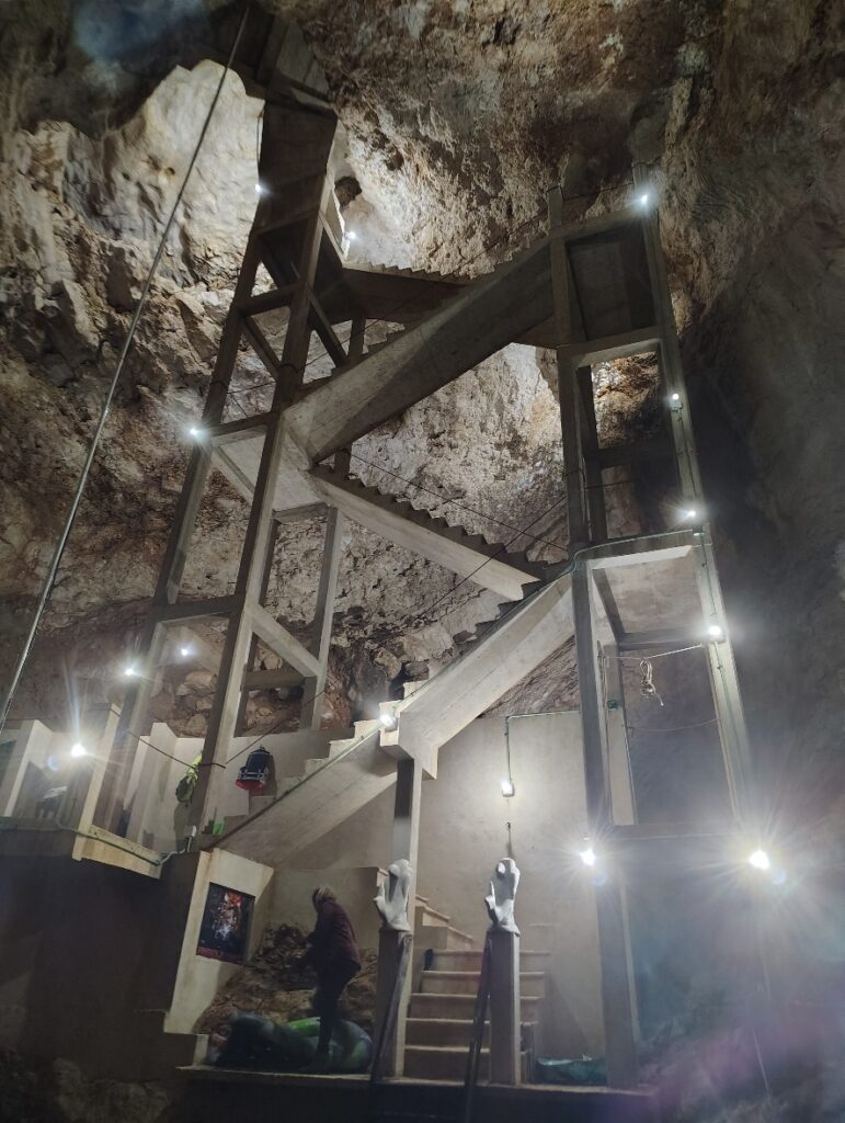 A picture of the tiered stairway descending into David's Cenote taken from the bottom looking up.